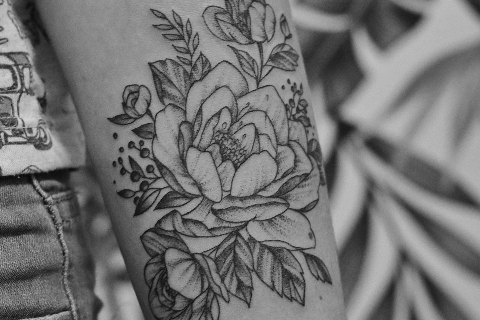 Black and grey floral tattoo detail on skin